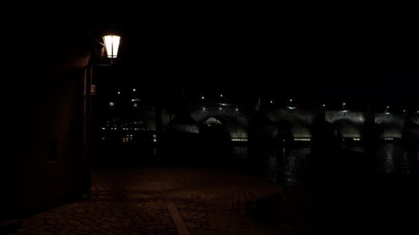 거리의 조명과 보행자들을 포장도로 그리고 밤에는 다리와 불빛을 수있고 프라하 — 비디오