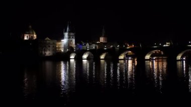 Charles Köprüsü 'nün gece görüşü ve gece aydınlığı ve Prag' ın merkezinde akan Vltava nehri.
