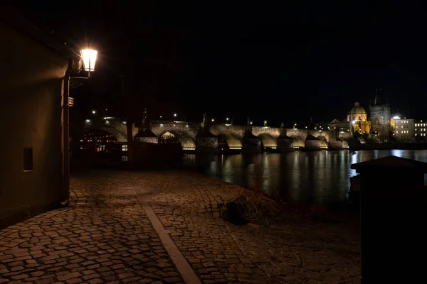 プラハ中心部のナイトパークやチェコ共和国プラハ中心部の背景にあるチャールズ橋の街路灯や舗装 — ストック写真