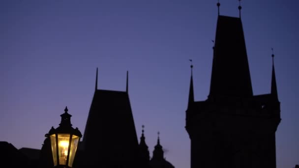 黄昏时查尔斯桥上一座塔的轮廓的街灯 — 图库视频影像