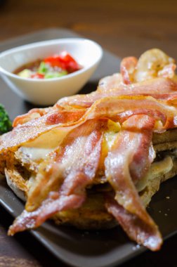 Kızarmış pastırmalı sandviç, domates ve turşu.