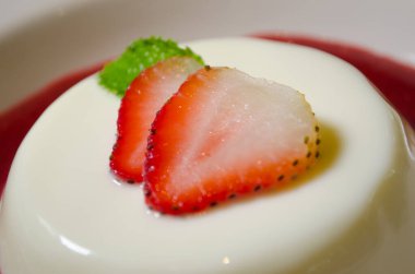 Çilekli ve naneli Panacotta kapağı, çilek soslu, seçici odaklı.