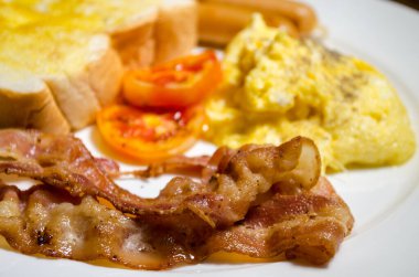 Çırpılmış yumurta, tost, domuz pastırması ve sosisli kahvaltı..