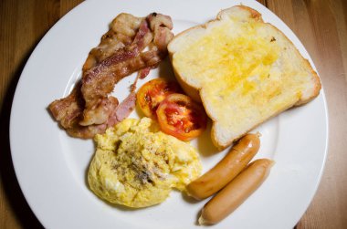 Çırpılmış yumurta, tost, domuz pastırması ve sosisli kahvaltı..