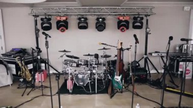 Müzik aletleri seti: zilli, saksafonlu davullar, iki elektrikli gitar, anahtarlar, mikser ve mikrofonlar müzik grubunun performansı için hazırlandı ve efekt yaratmak için ışık aygıtı var