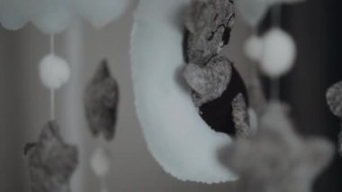 Bebek oyuncak ayı Ay 'da ve kumaş yıldızları bebeği sakinleştirmek ve eğlendirmek için bebek odasındaki yatağının üzerinde ince bir iplik üzerinde asılı duruyor. Kapat.