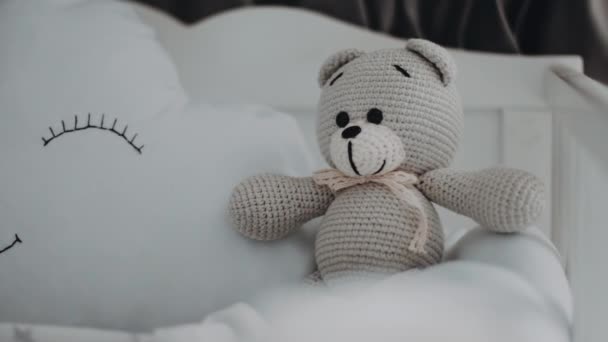 孩子们的玩具小灰熊在婴儿床里的一个白色枕头旁边坐着 形似云彩 — 图库视频影像