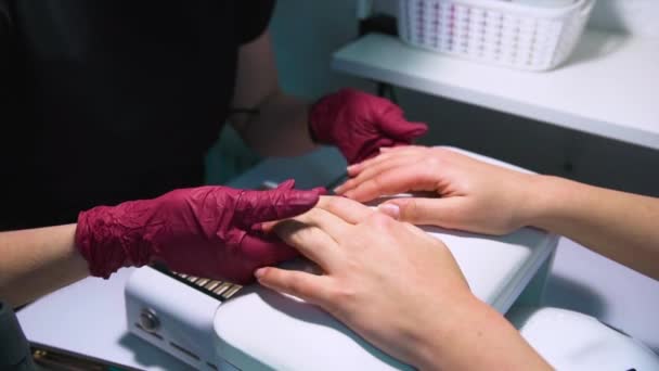 Salón Belleza Una Manicurista Caucásica Vestida Con Guantes Nitrilo Sostiene — Vídeo de stock