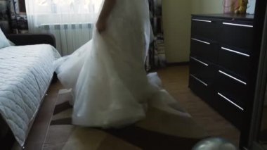 Karanlık bir odada, gelin beyaz, gür bir elbise içinde zarif bir dantelli ve peçeli bir şekilde duruyor..