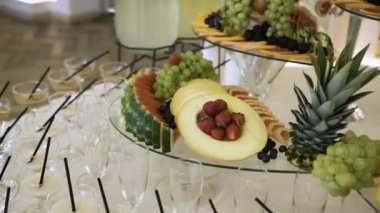 Taze organik meyveler: ananas, greyfurt, karpuz, kavun, üzüm, çilek, yabanmersini ve dut, dilimler halinde dilimler halinde dilimler halinde dilimlenmiş pahalı bir büfede alkolle birlikte restoranda duruyor.