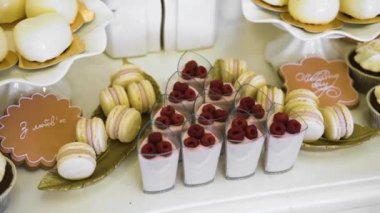 Lezzetli taze tatlılar: zencefilli kurabiyeler, küçük kurabiyeler, küçük kurabiyeler, kare şeklinde kekler ve kremalı tatlılar ve pastalar düğün günü restoranın masasındaki tatlı bir büfede duruyor.