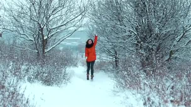 在冬天 非常快乐快乐的女孩在雪地上跑去参加会议 高兴地挥动着双手 满脸笑容 张开嘴 张牙舞爪 — 图库视频影像