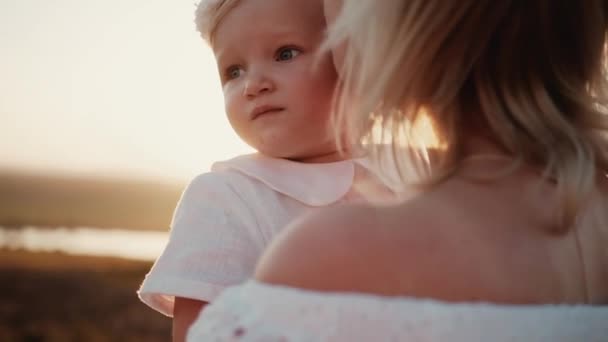 Liebevolle Zarte Mutter Hält Ihre Kleine Hübsche Tochter Bei Sonnenuntergang — Stockvideo