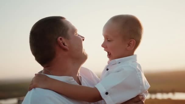 Liebender Fürsorglicher Vater Bei Sonnenuntergang Hält Einen Fröhlichen Lustigen Sohn — Stockvideo