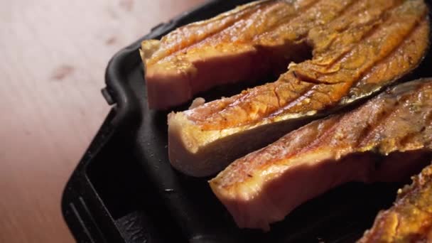 新鮮な赤鮭の魚のステーキは茶色で焼き グリルプレートにストリップが付いています 栄養価が高く健康的なオメガ3脂肪とおいしい ジューシーで健康的な食品 — ストック動画