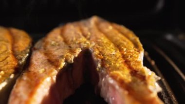 Kırmızı balıklı biftekler elektrikli ızgarada kızartılır. Somon parçaları yüksek sıcaklıkta pişirilir ve sulu bir iştah açıcı lezzetli kabuk ve yukarıdan yükselen buharla kaplanır.