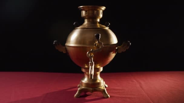黒い背景の暗い部屋のテーブルの上に立って 家の中でお茶のために水を沸かすために使用される金属青銅製の古いSamovar スプートと枝のクローズアップ それはハンドルです — ストック動画