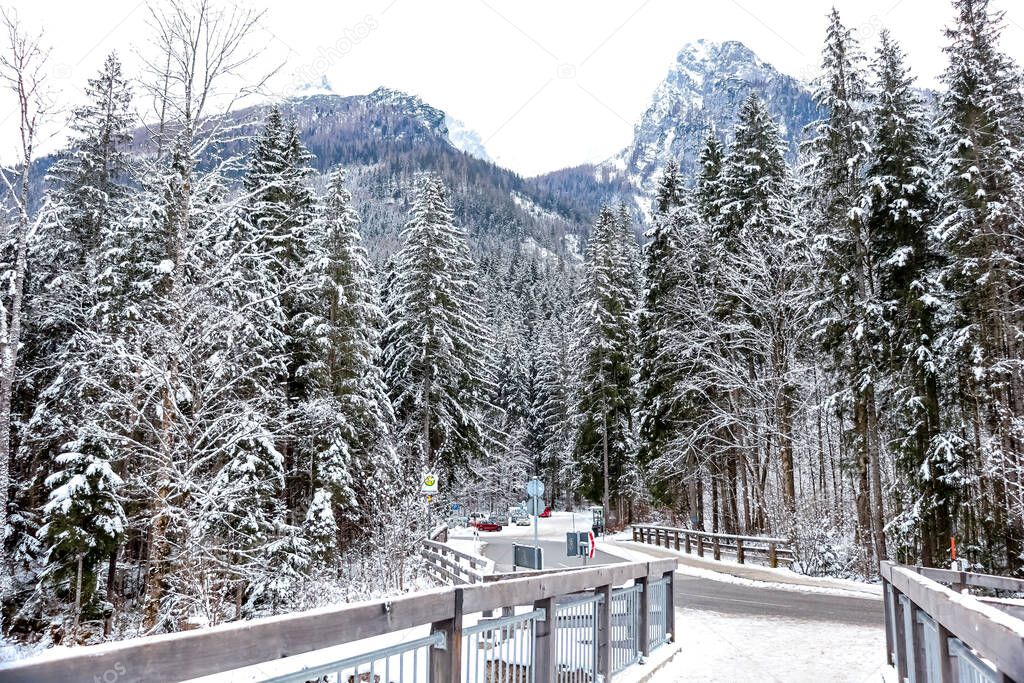 Landscape, bridge and street in the Bavarian alps on a winter day in January, with lot's of snow on the trees and mountains. Berchtesgadener Land