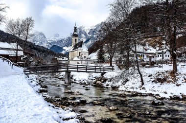 Kışın Ramsau 'daki tarihi kilise, Alman ulusal parkı Berchtesgaden' de, Knigssee ve Salzburg 'dan çok uzak değil. Arka plandaki küçük şapel ve dağlar birçok fotoğrafçı için ünlü bir dönüm noktasıdır..