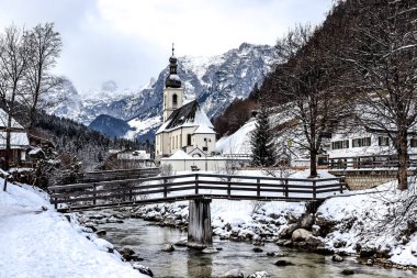 Kışın Ramsau 'daki tarihi kilise, Alman ulusal parkı Berchtesgaden' de, Knigssee ve Salzburg 'dan çok uzak değil. Arka plandaki küçük şapel ve dağlar birçok fotoğrafçı için ünlü bir dönüm noktasıdır.. 