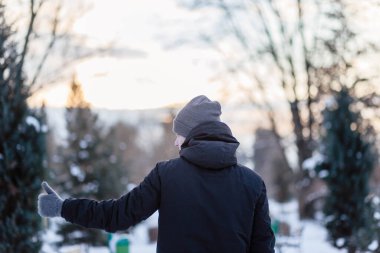 Adam sınıfı eldivenlerle gösteriyor. Gri kış eldivenli eller. Karda eldivenli bir avuç içi. Adam kar fırlattı..