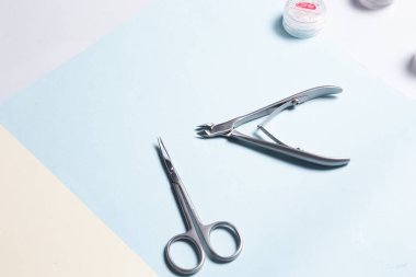 Sarı ve mavi arka planda manikür ve pedikür için bir takım kozmetik aletler. Tırnak makası, üst manzara..