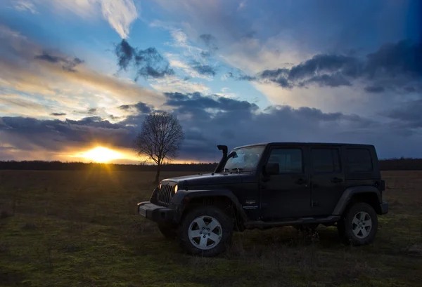 Novgorod region ,Russia, March 15, 2016: Photo of jeep Wrangler at sunset in the Novgorod region, USA. Wrangler is a compact four wheel drive off road and sport utility vehicle — Stock Photo, Image