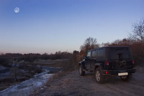 Región de Leningrado, el río Tosno, Rusia, 23 de marzo de 2016: Foto de un jeep Wrangler a orillas del río en la región de Leningrado, Estados Unidos. Wrangler es un compacto tracción en las cuatro ruedas de carretera y vehículo utilitario deportivo —  Fotos de Stock