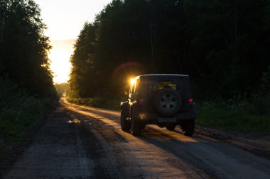 Novgorod oblast, Rusya, 03 Ağustos, 2015, Novgorod bölgesi kırsal bir yolda Jeep Wrangler Jeep Wrangler kompakt dört tekerlekli arabayla yol ve spor yeni araç kapalı olduğunu.