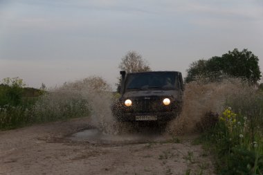 Novgorod oblast, Rusya, 03 Ağustos, 2015, Novgorod bölgesi kırsal bir yolda Jeep Wrangler Jeep Wrangler kompakt dört tekerlekli arabayla yol ve spor yeni araç kapalı olduğunu.