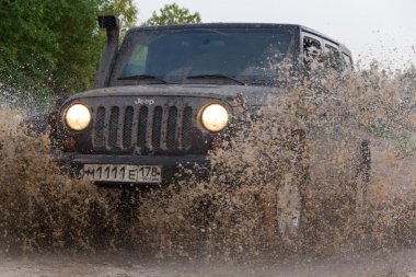 Novgorod oblast, Rusya, 03 Ağustos, 2015, Novgorod bölgesi kırsal bir yolda Jeep Wrangler Jeep Wrangler kompakt dört tekerlekli arabayla yol ve spor yeni araç kapalı olduğunu.