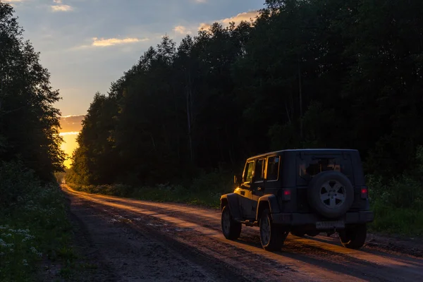 Novgorod oblast, Rússia, 03 Agosto, 2015, Jeep Wrangler em uma estrada rural na região de Novgorod, o Jeep Wrangler é um compacto quatro rodas de carro off road e veículo utilitário esporte — Fotografia de Stock