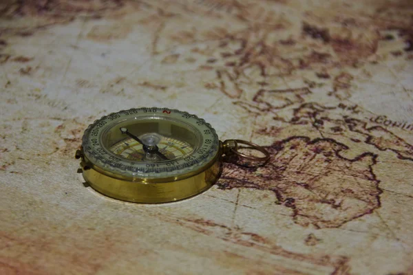 Old compass lying on a map — Stock Photo, Image
