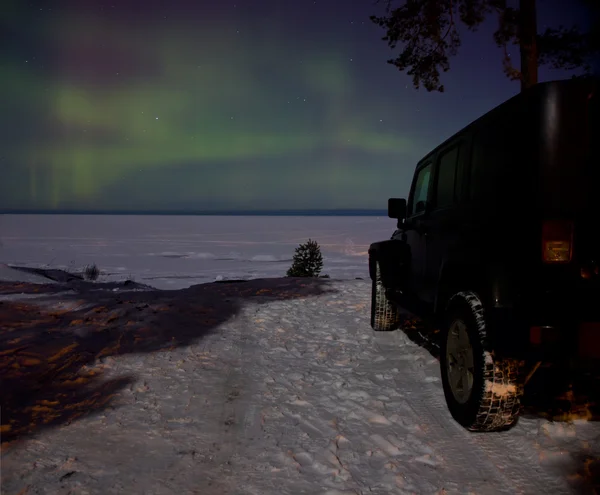 Leningrader Gebiet, Russland, 16. Februar 2016: Fotos eines Jeep-Wranglers am Ufer des Ladoga-Sees bei Nordlicht. Der Wrangler ist ein kompakter Geländewagen mit Allradantrieb und Sport Utility Vehicle — Stockfoto