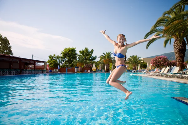 Chica alegre saltando en la piscina en vacaciones — Foto de Stock