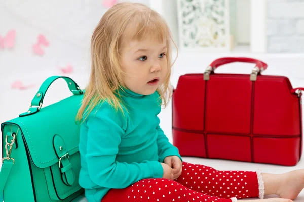 Little girl with leather bags — Stock Photo, Image
