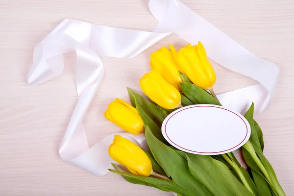 Žluté tulipány na dřevěném pozadí — Stock fotografie