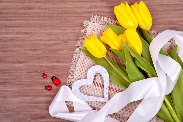 Banda žluté tulipány na dřevěné pozadí. Pružina — Stock fotografie