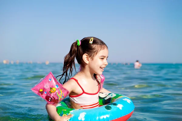 Little girl swimming in the sea buoy — Stock Photo, Image