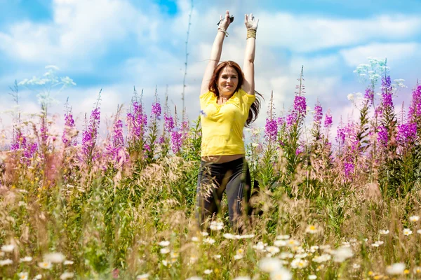 La niña se movió en un campo con flores moradas — Foto de Stock