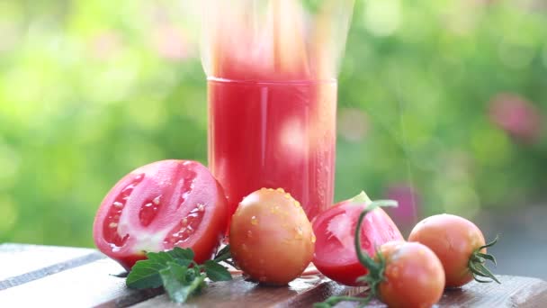 Splashes of fresh tomato juice and ripe tomatoes outdoors — Stock Video