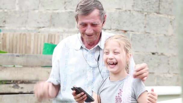 Glücklicher Opa mit Enkelin, die sich lachend im Hof umarmt — Stockvideo