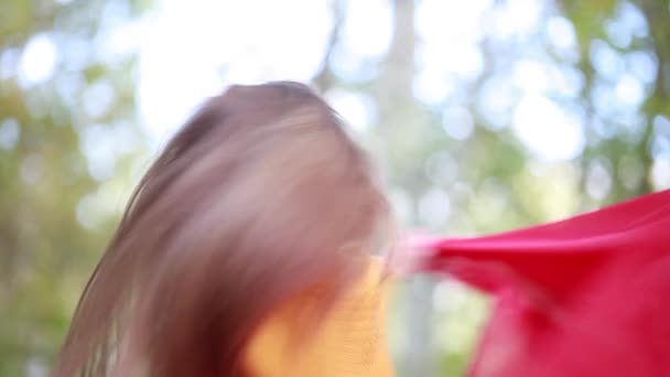 Hermosa chica con el pelo largo ondeando tela de seda roja — Vídeo de stock