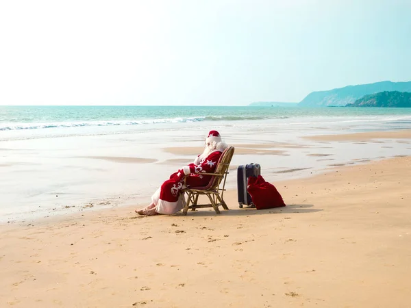 Noel Baba, okyanus kumlu tropikal plajda güneşlenerek dinleniyor. Sıcak ülkelerde xmas tatili konsepti. — Stok fotoğraf