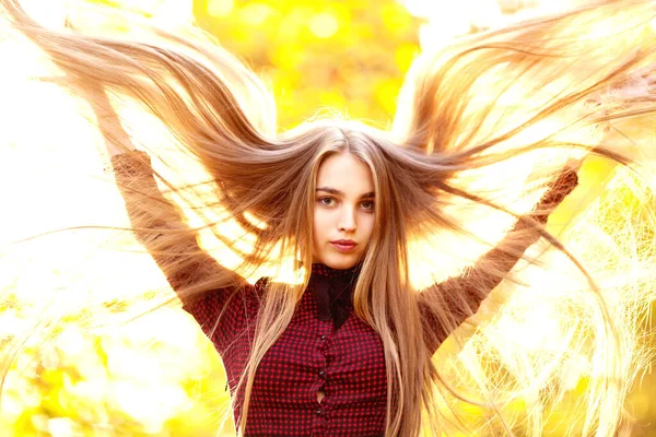 Krásná dívka v šatech, s dlouhou přírodní světle hnědé vlasy třepotající se na stranu v přírodě na podzim, Royalty Free Stock Obrázky