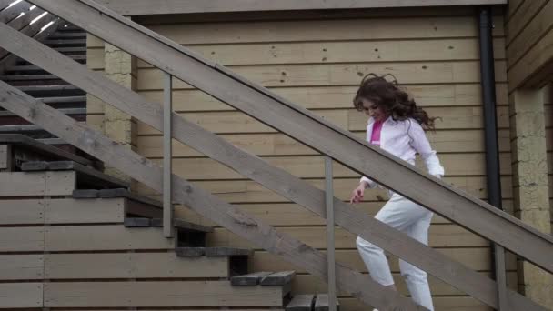 Šťastná žena tančící na venkovním schodišti. Módní dívka životní styl koncept. — Stock video