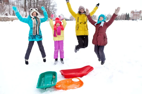 Allegra compagnia di bambini che saltano in una passeggiata invernale pomeridiana — Foto Stock