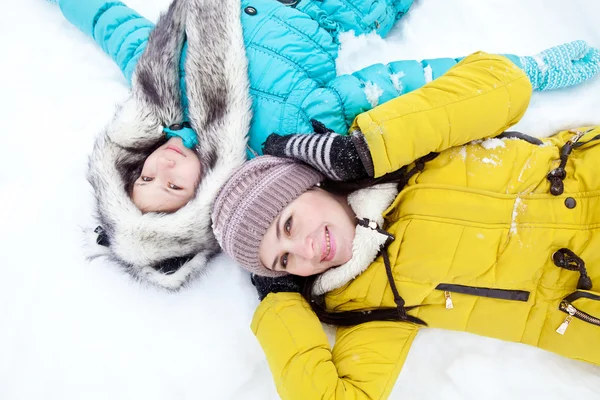 Madre e figlia si trovano sulla neve — Foto Stock