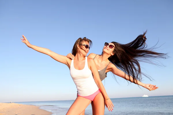 Glada glada tjejer på stranden — Stockfoto
