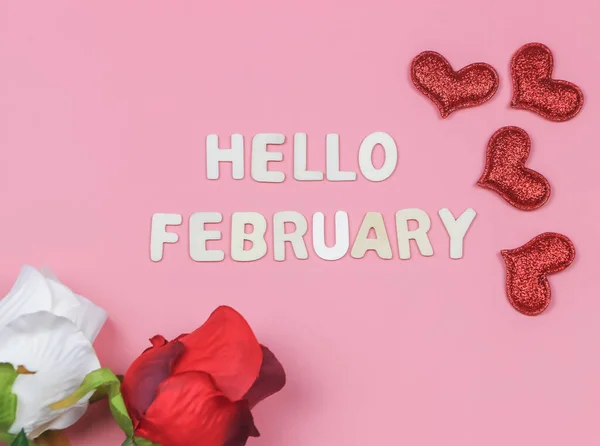 木製の文字のトップビューまたはフラットレイアウトピンクの背景に赤と白のバラ 赤の輝きの心を持つHello February 新しい月とバレンタインデーを迎える — ストック写真